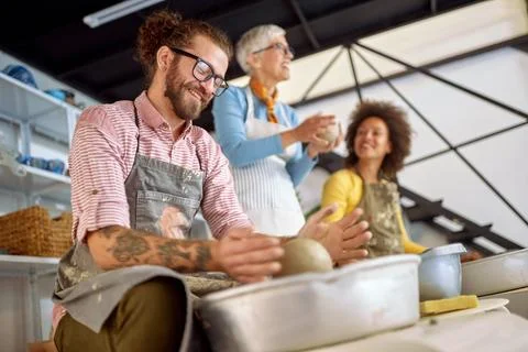 Group of students making clay pot on wheel at pottery workshop.  Creative, .. Stock Photos