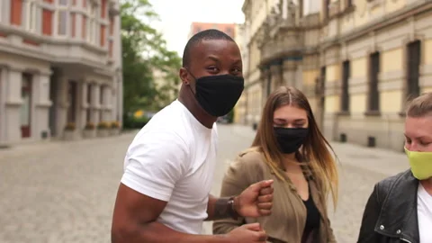 A group of students in protective masks dance on a city street. Two white girls Stock Footage 132066591