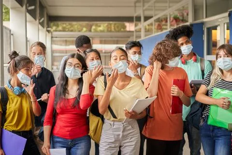 Group of students putting on or taking off their face masks. Young people of Stock Photos
