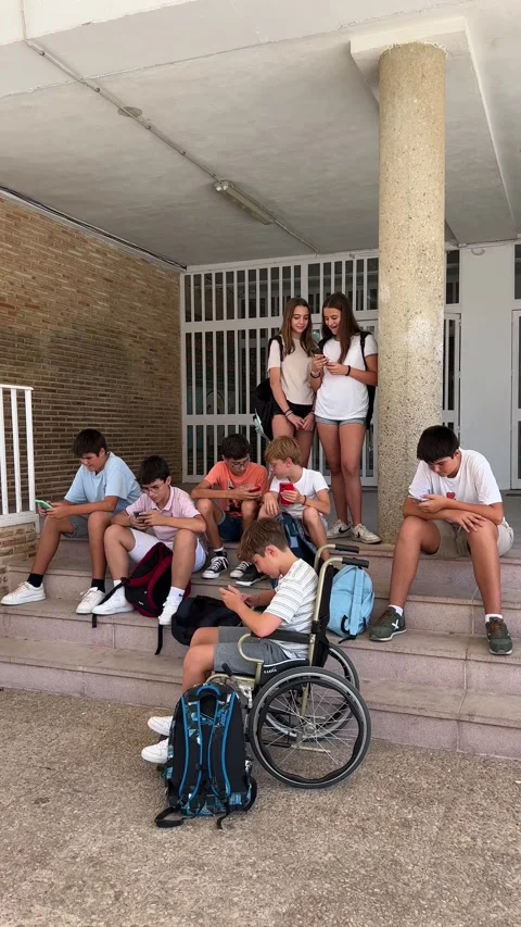 A group of students at the school gate using their cell phones. Stock Footage 248956915