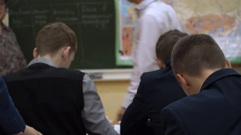 A group of students sit in a school class and work on the task. Some students ar Stock Footage 100034043