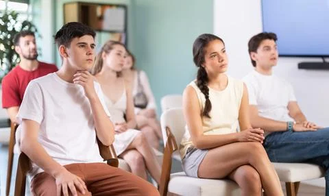 Group of students sits in auditorium and listens attentively to a lecture. Stock Photos