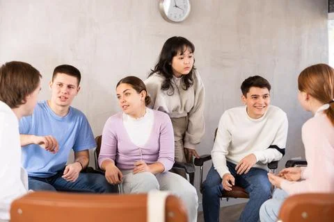 Group of students sitting in circle studying together in study hall of Stock Photos