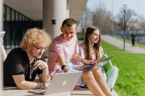 Group of students studying and using laptops outside a modern university Stock Photos