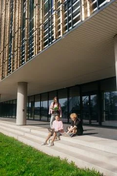 Group of students studying and using laptops outside a modern university Stock Photos