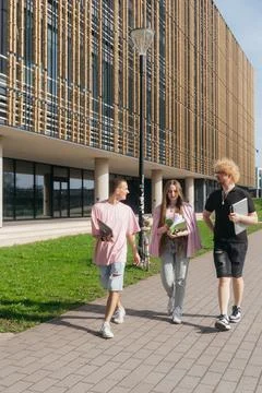 Group of students studying and using laptops outside a modern university Foto stock