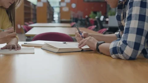 Group of students studying together in library. Two Asian students learning.. Stock Footage 323045758