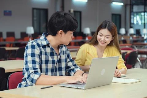 Group of students studying together in library. Two Asian students learning.. Stock Photos