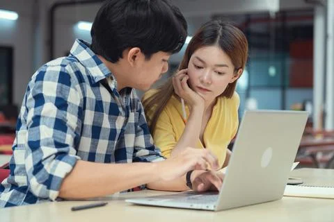 Group of students studying together in library. Two Asian students learning.. Stock Photos