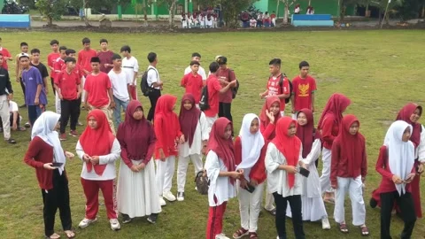 A group of students wearing red and white gathered in the yard Stock Footage 282416065