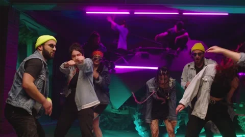 Group of stylish young people dancing , moving near military tank inside garage Stock Footage 169481766