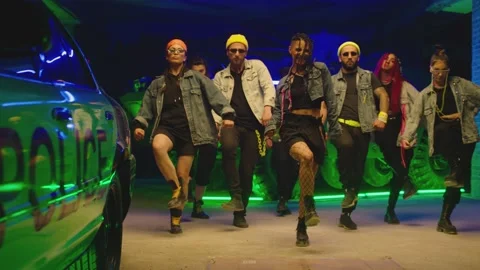 Group of stylish young people dancing synchronized dance near military tank Stock Footage 169616100