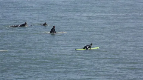 Group of Surfers floating in the ocean waiting for the perfect wave Stock Footage 64256808