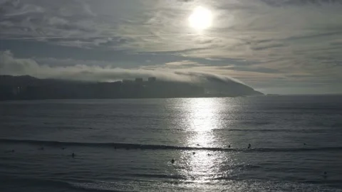 A group of surfers on the ocean during sunset. Reflection of the sun on the Stock Footage 232396760