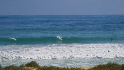 A group of surfers waiting to catch waves in the ocean in summer Vídeo Stock 93731893
