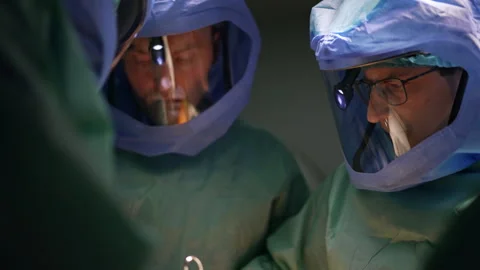 Group of surgeon in protective suits cooperate at surgery. Stock Footage 241124830