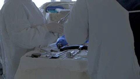 A group of surgeons' doctors selects special instruments for leg surgery. Video stock 95231922