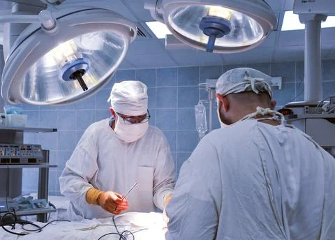 Group of surgeons in operating room with surgery equipment. Modern medical ba Stock Photos