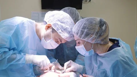 A group of surgeons perform surgery on the face. Plastic surgery, facelift Stock Footage 124402303