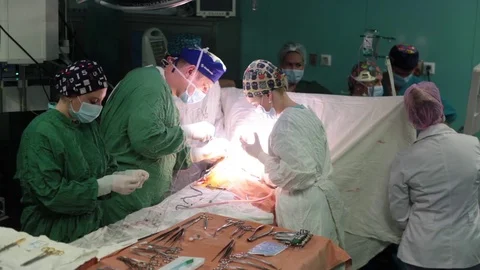 The group of surgeons standing near the operating table. doing surgery Stock Footage 70810437