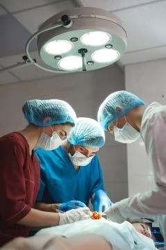 Group of surgeons at work operating in surgical theatre. Resuscitation medicine Stock Photos