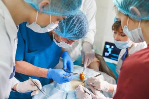 Group of surgeons at work operating in surgical theatre. Resuscitation medicine Stock Photos