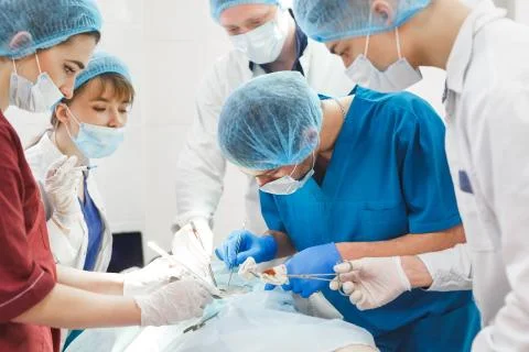 Group of surgeons at work operating in surgical theatre. Resuscitation medicine Stock Photos