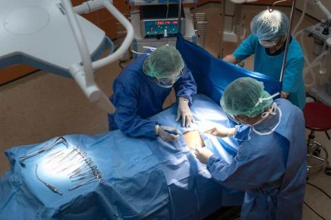 Group of surgeons at work in operating theater. Medical team performing opera Stock Photos