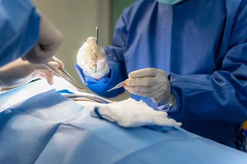 Group of surgeons at work in operating theater. Medical team performing opera Stock Photos