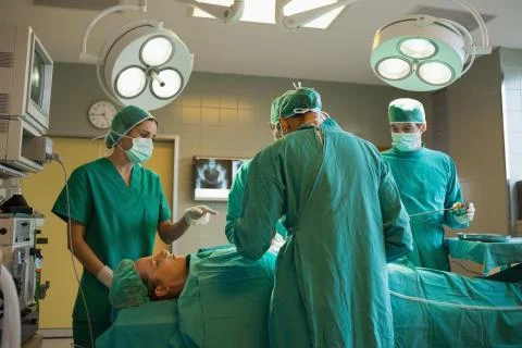 Group of surgeons working on a female patient Stock Photos