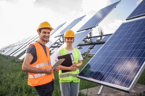Group of technicians engineer at solar power farm standing in the safety uniform Foto stock