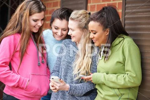 Group Of Teenage Female Friends Reading Text Message Stock Photos