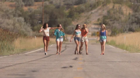 Group of Teenage Girls Walk Arm In Arm Down The Road Stock Footage