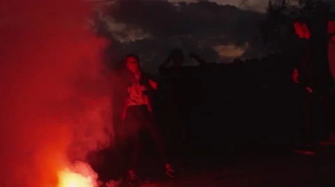 Group of Teenagers Hanging Out and Dancing in Light of Red Signal Flare Outdoors Stock Footage