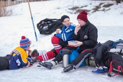 Group of teenagers having a snack while playing hockey Stock-Fotos