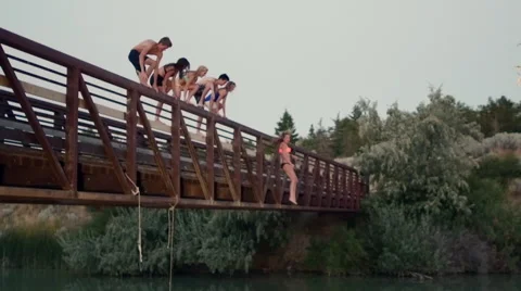 Group Of Teens Jump Off Bridge, One At A Time, Into River Below (Slow Motion) Видео 47496350