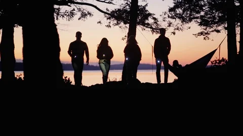 Group of teens walking by coast at dusk with flashlights Stock Footage 87532944