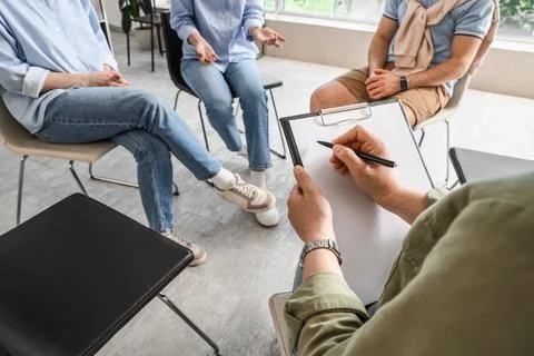 Group therapy session with counselor taking notes Stock Photos