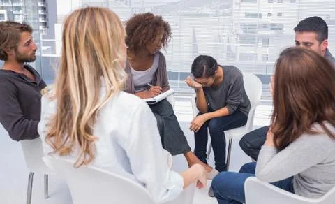 Group therapy session with one woman crying Stock Photos