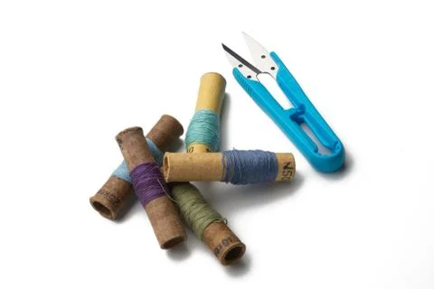 Group of thread spools white background with repairing scissors Stock Photos