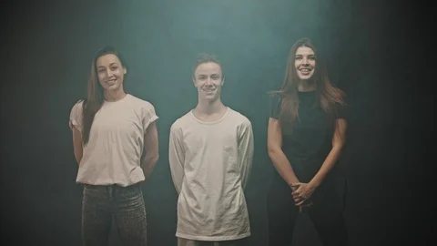 A group of three dancers standing in the line and laughing - looking in the Stock Footage 124129994