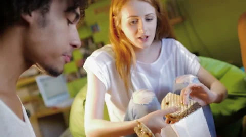 A group of three hipster eating and having fun using a tablet computer Stock Footage 54938557