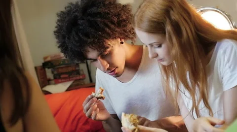 A group of three hipster eating and having fun using a tablet computer Stock Footage 54938631