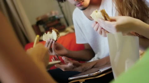 A group of three hipster eating and having fun using a tablet computer Stock Footage 54938670