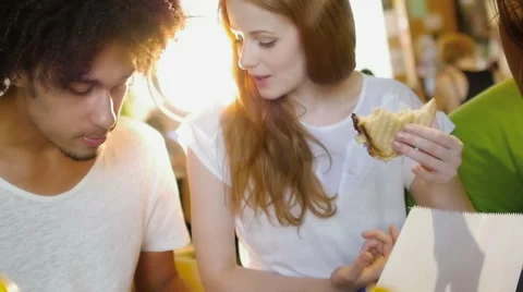 A group of three hipster eating and having fun using a tablet computer Stock Footage 54938704