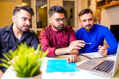 Group of three indian students looking at laptop indoors Stock Photos