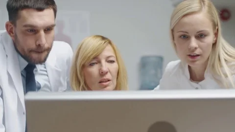 Group of Three Medical Specialists Solving Problems at the Desktop Computer. Stockbeeldmateriaal 70429107