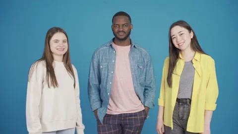 Group of three multiethnic model friends dancing while looking at camera Stock Footage 228810097