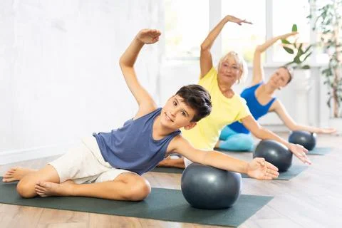 Group of three people doing physical education with softball in classroom Stock Photos