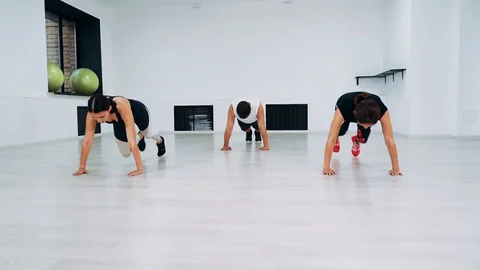 Group of three people make climber exercise in studio. Men and girls are engaged Video stock 114164316